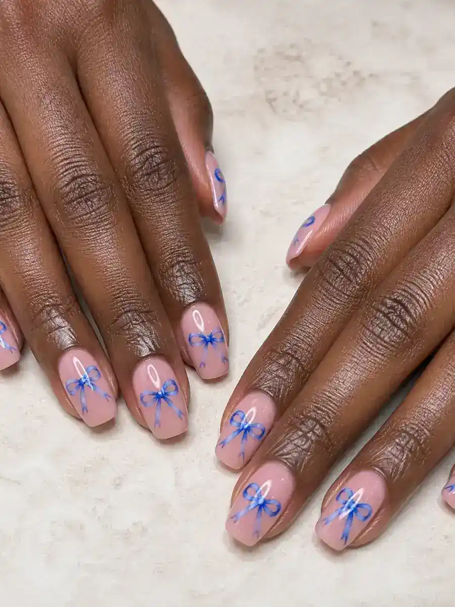 Blue Bow Nail Design: pink base, painted bow accent, blue bow nail design