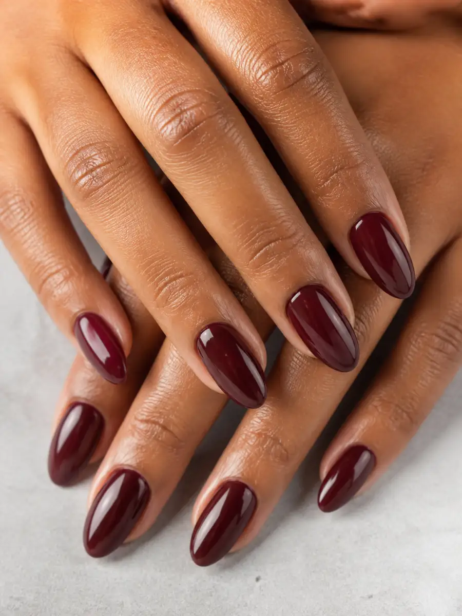 Burgundy Oval Nails: almond, muted shade, glossy finish, burgundy oval
